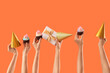 © Pixel-Shot - Many female hands with birthday cupcakes, gift box and party hats on orange background