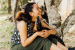 © Mario Vásquez Rioja - Mujer feliz al aire libre interactuando con un pequeño mono y un coatí con cariño, celebrando la conexión con la fauna en el Día Mundial de los Animales.