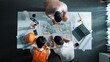 © InfiniteFlow - Top down aerial view of smart architect engineer team pointing and discussing about building construction. Group of diverse people working together to plan and design by using blueprint. Alimentation.