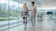 © zuchero - Senior Woman Using Rehabilitation Exoskeleton With Therapist in Modern Recovery Center