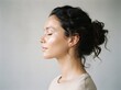 © Bongopi  - Serene woman with closed eyes in profile, meditating in a calm and peaceful indoor setting with soft natural light