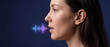 © itlada - AI voice recognition concept with a side profile of a young woman speaking near a glowing digital soundwave on a dark blue background, ideal for biometric security and smart assistant designs