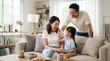 © Masque - Happy Asian family enjoying quality time together at home.