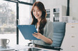 © ARMMY PICCA - Businesswoman working with tablet and financial reports in modern office
