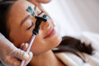 © Home-stock - Closeup of woman enjoying professional skincare session while beauty specialist applying purifying charcoal mask to T-zone for deep cleansing