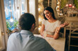 © Westend61 - Portrait of smiling young woman talking to her boyfriend in a restaurant
