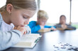 © Westend61 - A diligent schoolgirl engrossed in reading during her break in the school's cozy break room