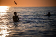 © Zoran Jesic - Children swimming in ocean during tranquil sunset hour