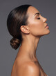 © paultarasenko - Elegant side profile portrait of a beautiful woman with her dark hair styled in a sleek low bun