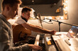 © Niyaz Tavkaev/Stocksy - Male Song writer creating song with friend. Men in sound studio