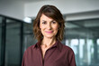 © Stock 4 You - Close up face portrait of middle aged mature businesswoman in office. Attractive woman looks at camera with light smile. Confident female business director, professional in 50s poses at workplace.