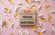 © Natallia - Blood Pressure Monitoring symbol. Concept words Blood Pressure Monitoring on wooden blocks. Beautiful pink background with pills. Healthcare and Blood Pressure Monitoring concept. Copy space.