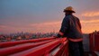 © GATE 22 - Firefighter standing on the edge of a fire truck, looking out over a city skyline at sunset.