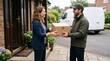 © Felippe Lopes - Delivery person hands a package to a smiling woman at her doorstep with a van in the background
