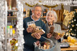 © JackF - Visiting store on New Years Eve, elderly married couple purchase desserts and sweet snacks. They choose and consider nougat, chocolate bar, marzipan, candies, marzipan.