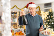 © JackF - Happy elderly man buying bottles of wine at grocery supermarket to celebrate Christmas