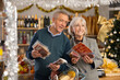 © JackF - While shopping on eve of New Year holidays, elderly couple filled basket with food, choosing meat delicacies. They are considering buying hamon and vacuumed slicing smoked sausage.