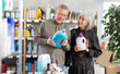 © JackF - Senior spouses buyer select and studies label, read composition of liquid detergent. Client examine product, make purchase decision and discusses advantages and properties of product.