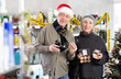 © JackF - Couple elderly man and woman choosing perfume and cosmetics in household chemicals store decorated for christmas