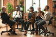 © DC Studio - Recovery group applauding woman during therapy meeting inside a group counseling session focused on listening, trust and mental health recovery.