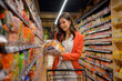 © Apichat - Woman selecting instant noodles in supermarket aisle
