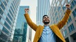 © Pete - Man raises arms in city, expresses joy and triumph. Business success, career achievement, personal victory. Skyscrapers backdrop signifies ambition and goal attainment.