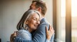 © Angavlan - Emotional embrace of older couple smiling joyfully in bright office space. Warm moment captures connection between older individuals celebrating relationship in professional setting.