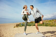 © Westend61 - Happy mature couple stretching legs at beach