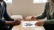 © Таня Андреева - Diverse couple sits at wooden table pointing at inkblot during psychological therapy session in calm home office
