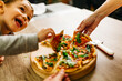 © Westend61 - Father and son picking up pizza slices