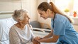 © waragron - A young nurse warmly holds hands and smiles at an elderly woman in a hospital bed, conveying care and compassion.