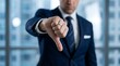 © Pixim Stock - Dissatisfied professional businessman wearing suit and tie showing thumbs down gesture in office setting expressing disapproval disappointment disagreement rejection failure and negativity.