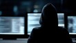 © Firadoaw - hacker sitting at desk with multiple monitors showing code and cyber attack interface