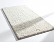 © Mountea - A soft, plush, cream-colored rectangular rug with a textured surface