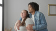 © Krakenimages.com - Man holding plus size woman with arm around shoulder and hand on upper arm, both smiling in studio; intimacy love connection.