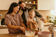 © La Famiglia - Happy family baking together in modern kitchen