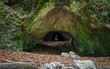 © Tibor - Lone hiker standing at the entrance of Kőrös-lyuk Cave, highlighting the impressive scale of this natural limestone cave in Bükk National Park, Hungary.