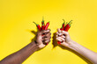 © ADDICTIVE STOCK - Multiethnic hands holding red chili pepper on yellow