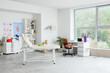 © Pixel-Shot - Modern physical therapy and rehabilitation clinic interior with massage table, medical equipment, and large window