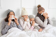 © Pixel-Shot - Ill family with tissues sneezing in bedroom