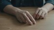 © Arzen - Close up of human hands tapping fingers on a wooden table surface, person gesturing during meeting, indoor office setting, moody cinematic lighting with shallow depth of field and copy space