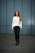 © Westend61 - Portrait of long-haired young woman wearing white knit pullover and black trousers