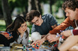 © qunica.com - High school students study science together on a park blanket using anatomy and molecular models. The group of teens collaborate on a hands-on learning project outdoors.