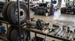 © skarida - Truck wheel service station with large tire, hub assembly, wrenches, sockets, and parts on a workshop floor for commercial vehicle maintenance