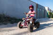 © KikoStock - Young girl driving a quad bike on a dirt road