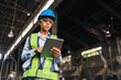 © chokniti - Engineer factory tablet hard hat safety vest woman industrial worker inspection female engineer using tablet during factory inspection with hard hat, safety vest, glasses, focused expression