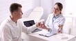 © New Africa - Gastroenterologist giving pills to patient in clinic