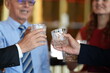 © ultramansk - A group of friends at the hotel bar, clinking whiskey glasses in celebration at an elegant hotel cocktail bar, showcasing world class hotel service and style, looking calm and content.
