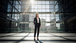 © fackul - Woman in suit looking up at sunlit modern office atrium with glass walls, ideal for corporate branding, professional lifestyle and business success stories