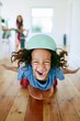 © Iryna - Vertical portrait of an ecstatic child on a skateboard wearing a helmet for playful kids poster and wall wallpaper design